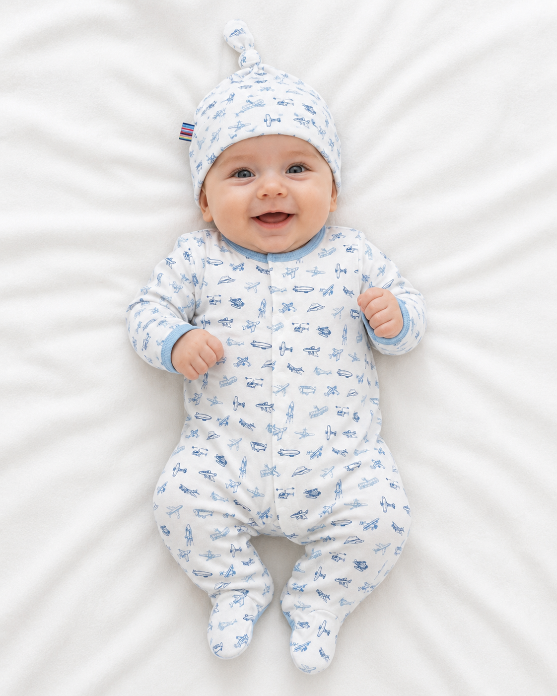 baby boy in airplane themed magnetic footie sleeper and matching beanie