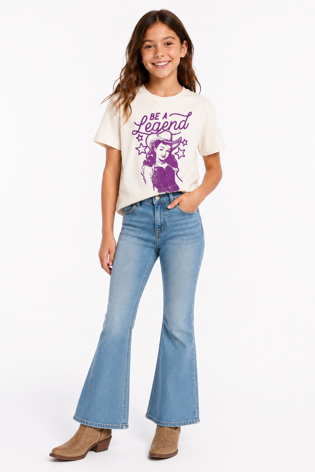 Young girl wearing a western graphic t-shirt with text and design, paired with blue jeans on a white background