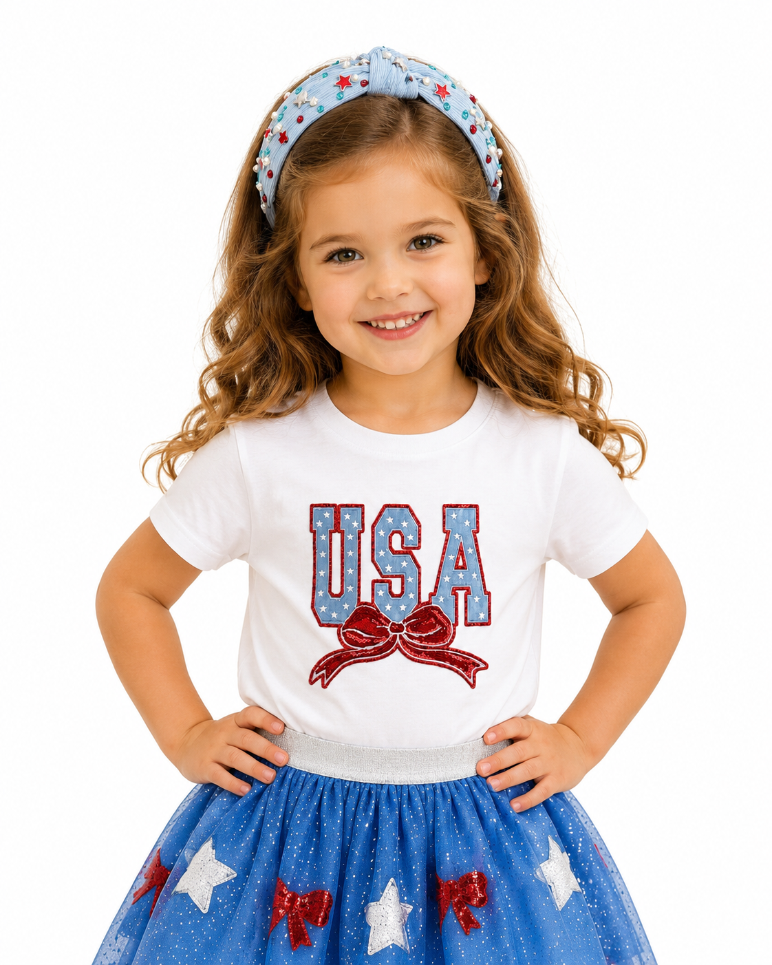 Young girl wearing a white shirt with 'USA' and a blue skirt with star patterns on a white background