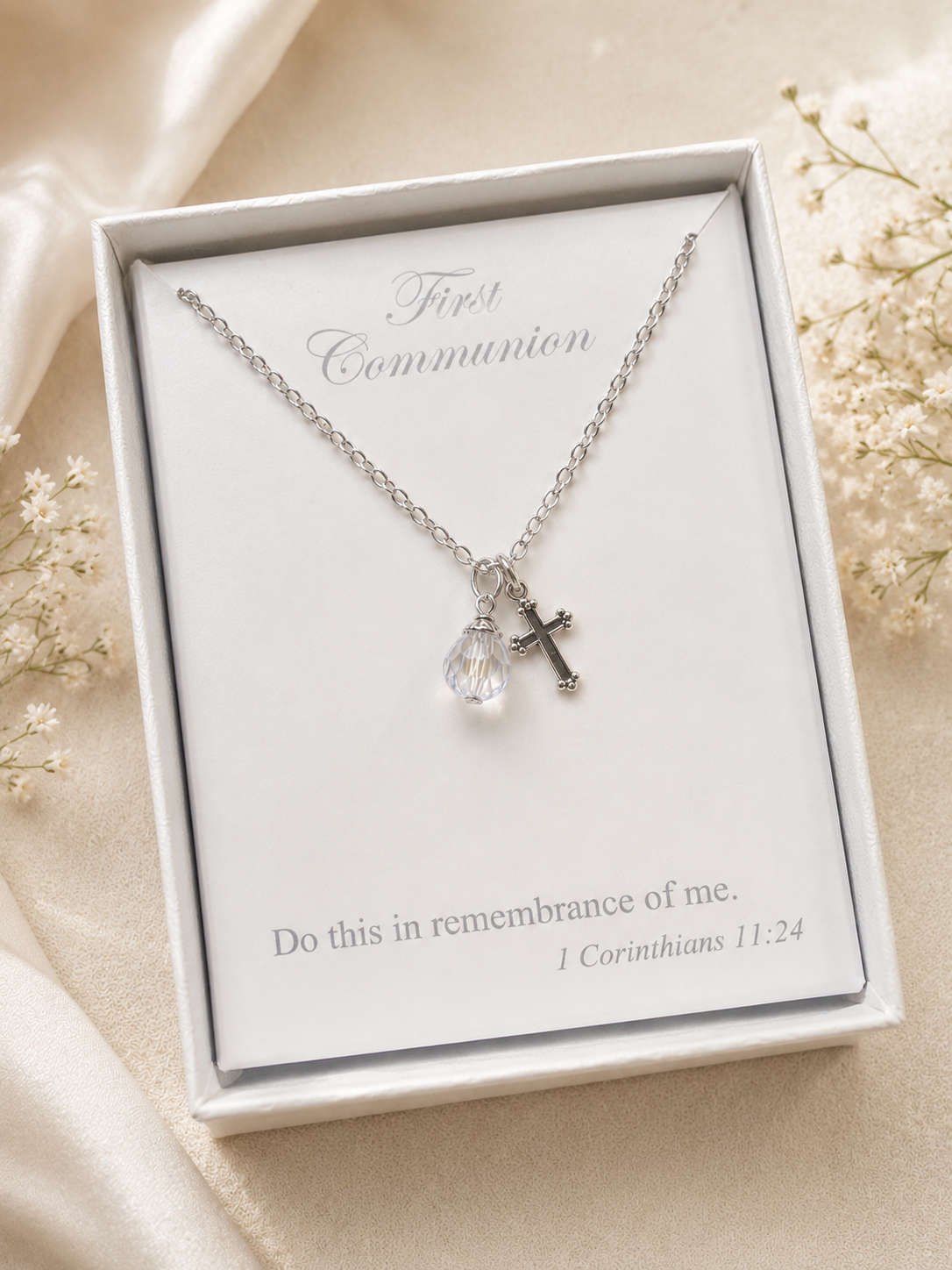 Silver necklace with a heart and key pendant in a white box on a beige background