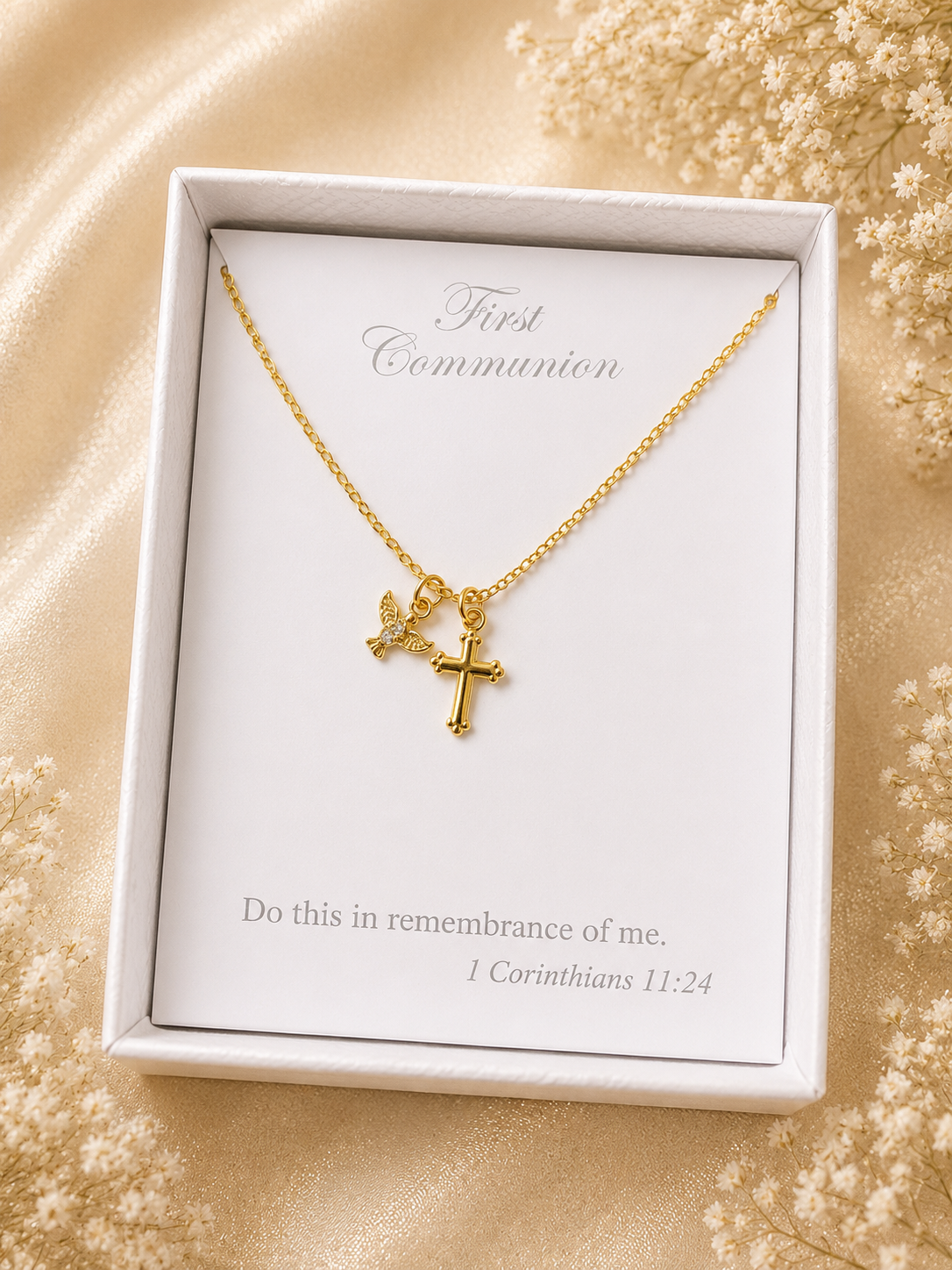 Gold necklace with cross pendant in a white box on a beige background