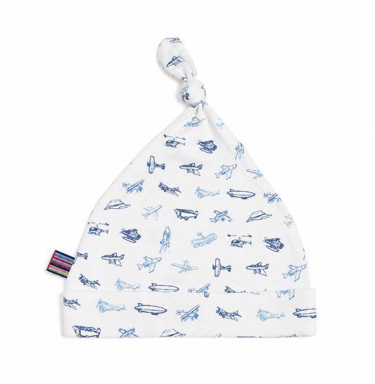 White baby hat with blue airplane patterns on a white background