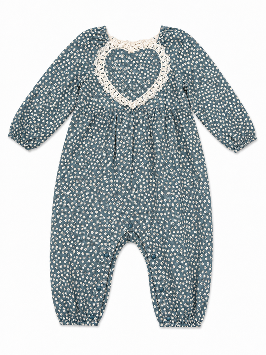 A baby long-sleeve romper in a slate blue-gray color with a white daisy print, featuring a white lace heart-shaped neckline.