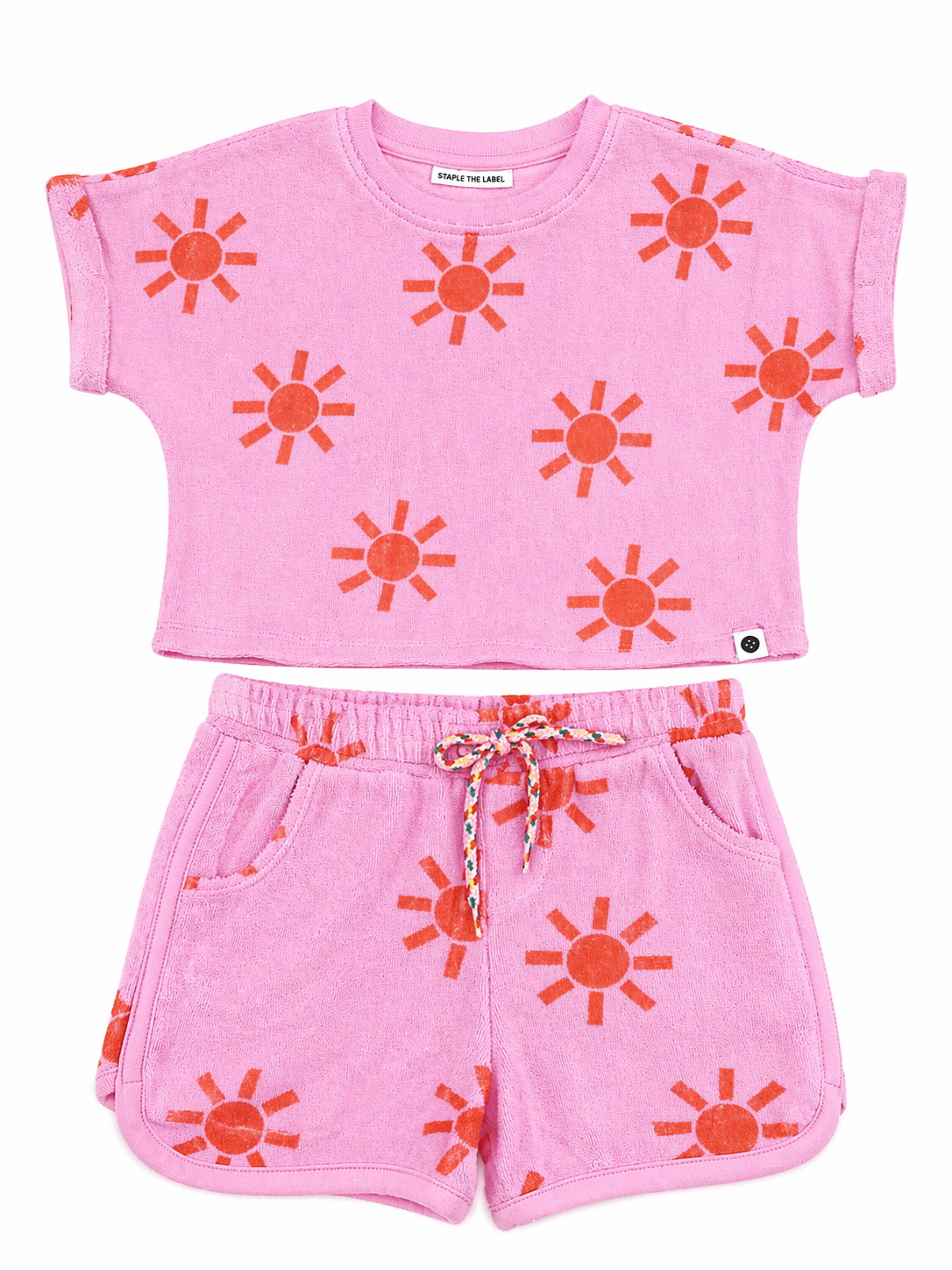 Pink children's outfit with sun patterns on a white background