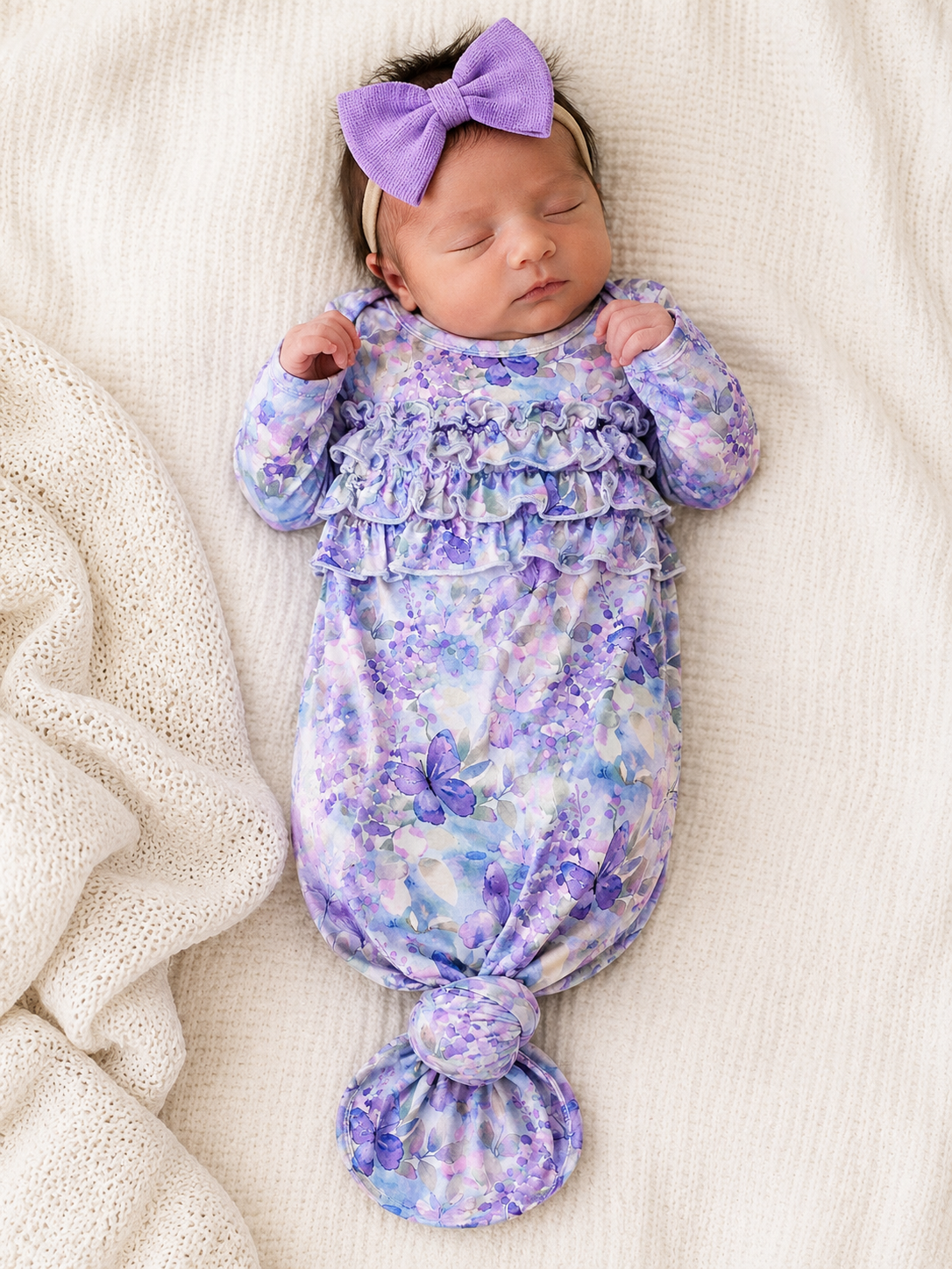Newborn baby in a floral knot gown made from bamboo sleeping 