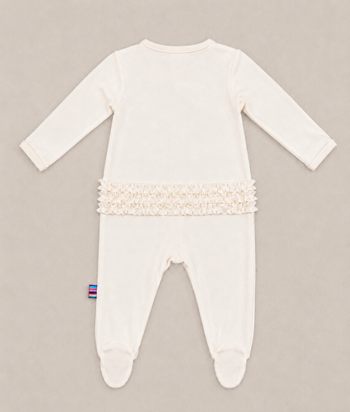 the backside of cream baby girl ruffle footie sleeper with magnetic closure 