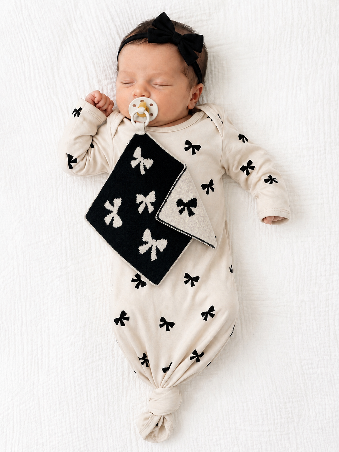 baby with pacifier blankie black and white bow pattern 