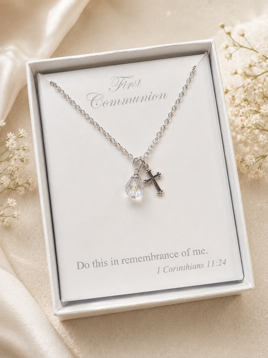 Silver necklace with a heart and key pendant in a white box on a beige background