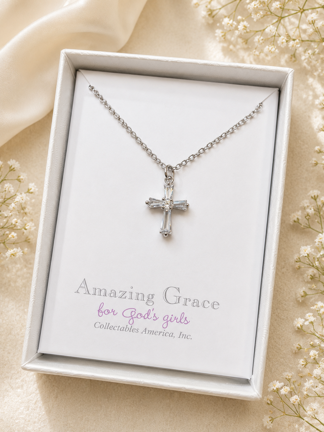 Silver cross necklace in a 'Amazing Grace' box with flowers around
