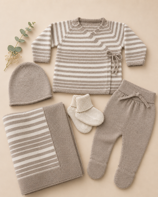 Baby clothing set with striped sweater, pants, hat, and socks on a beige background
