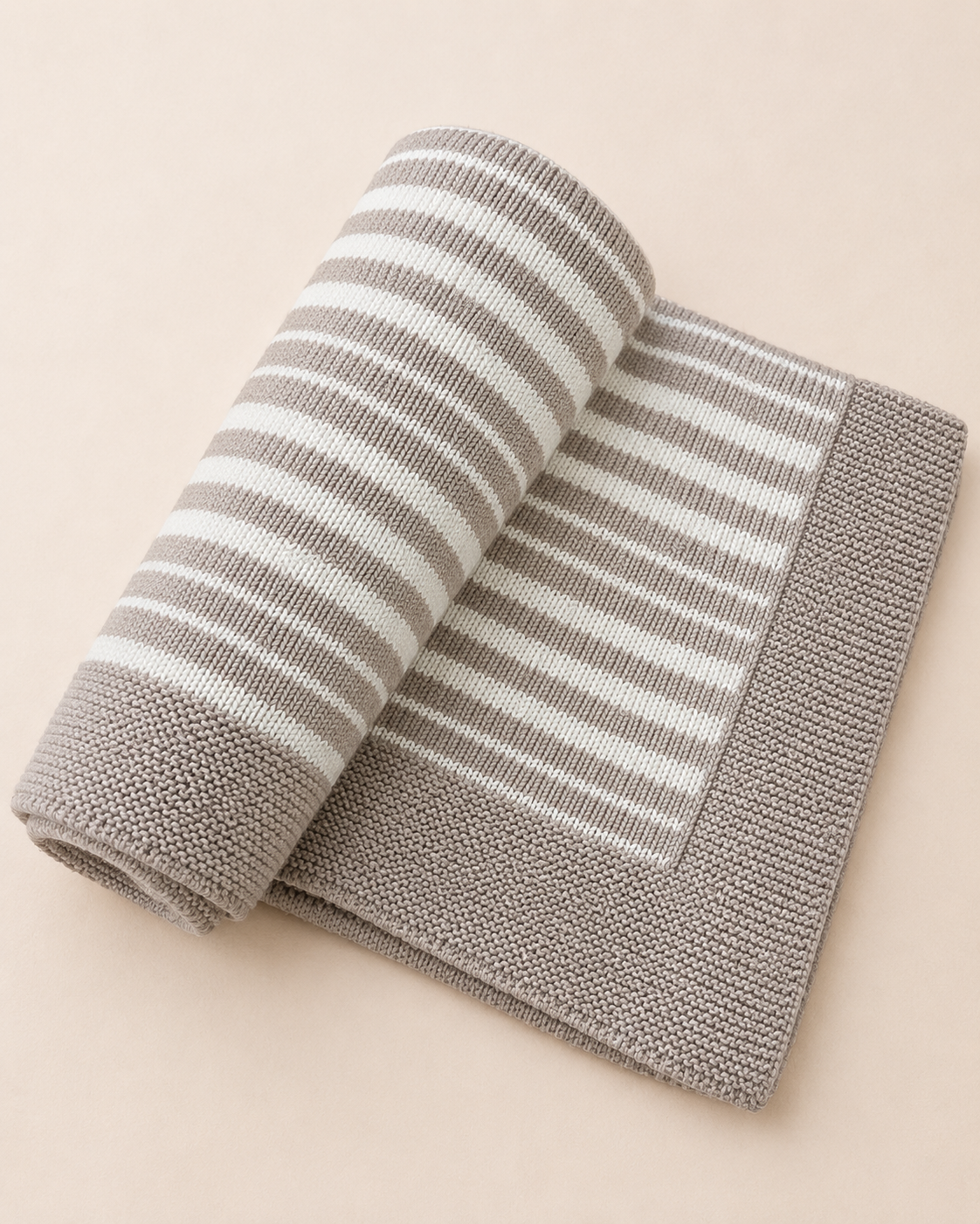 Rolled-up gray and white striped towel on a beige background