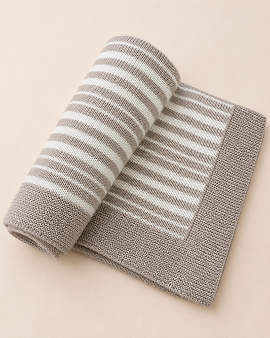 Rolled-up gray and white striped towel on a beige background