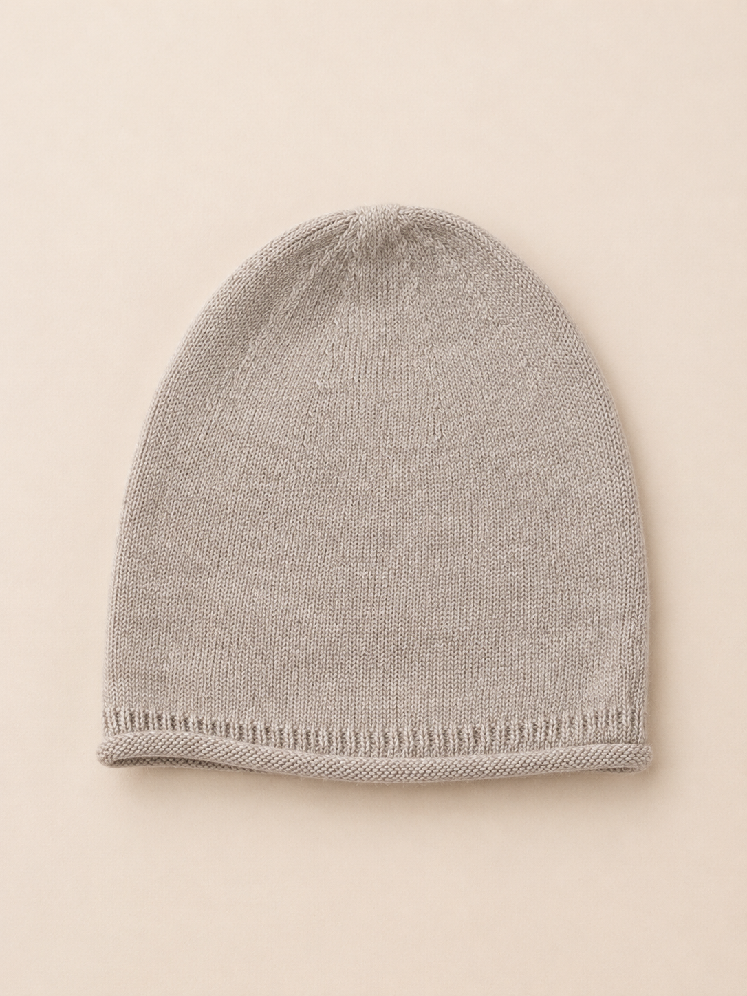 Gray knit beanie on a beige background