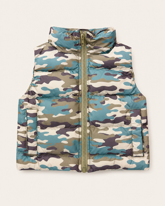 A sleeveless puffer vest with a high collar and front zipper, featuring a blue, green, beige, and brown camouflage pattern, shown flat against a light cream background.