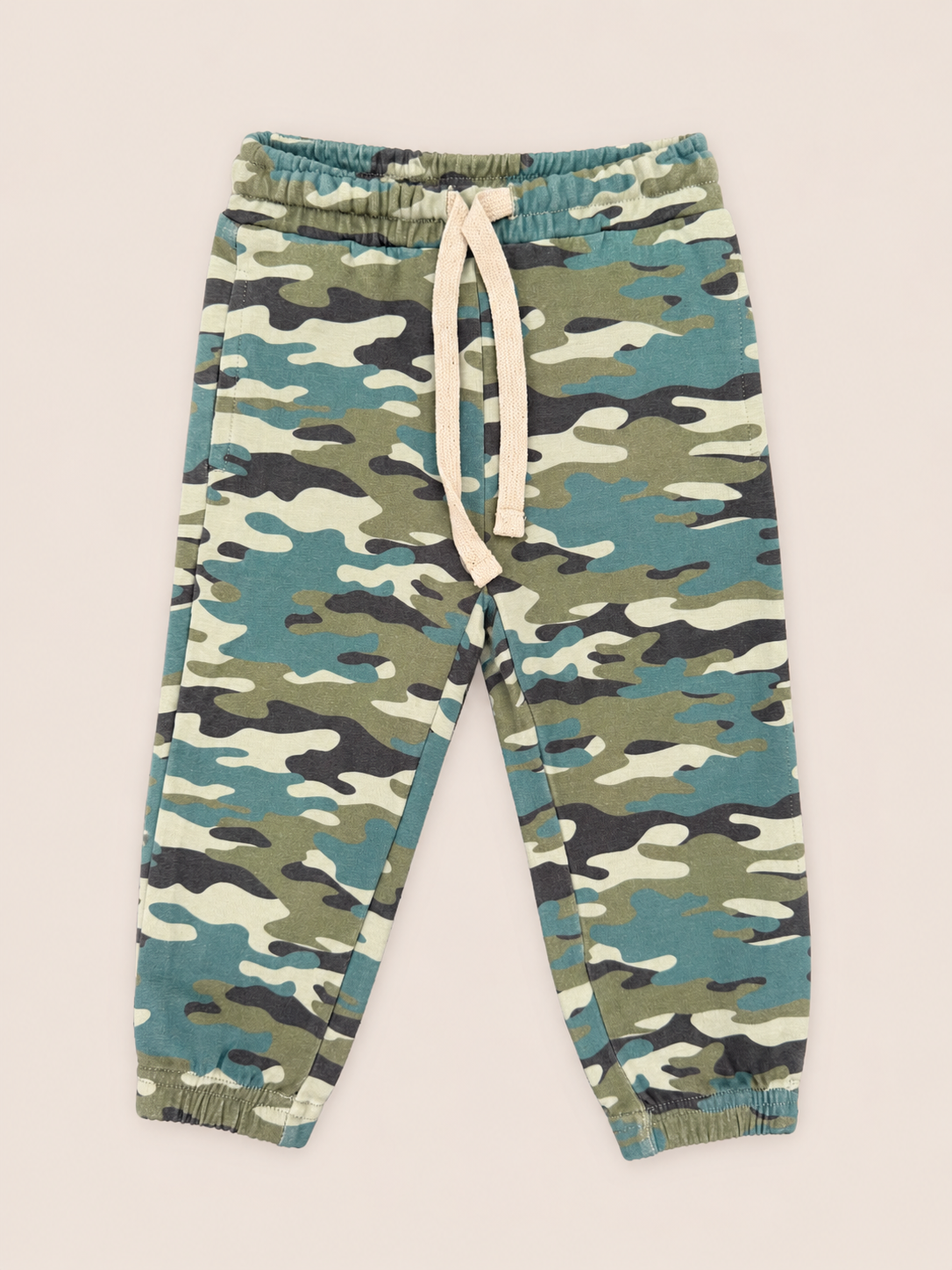 Kids' camouflage jogger pants in a blue, green, and beige camo pattern with an off-white drawstring, shown flat on a light beige background.