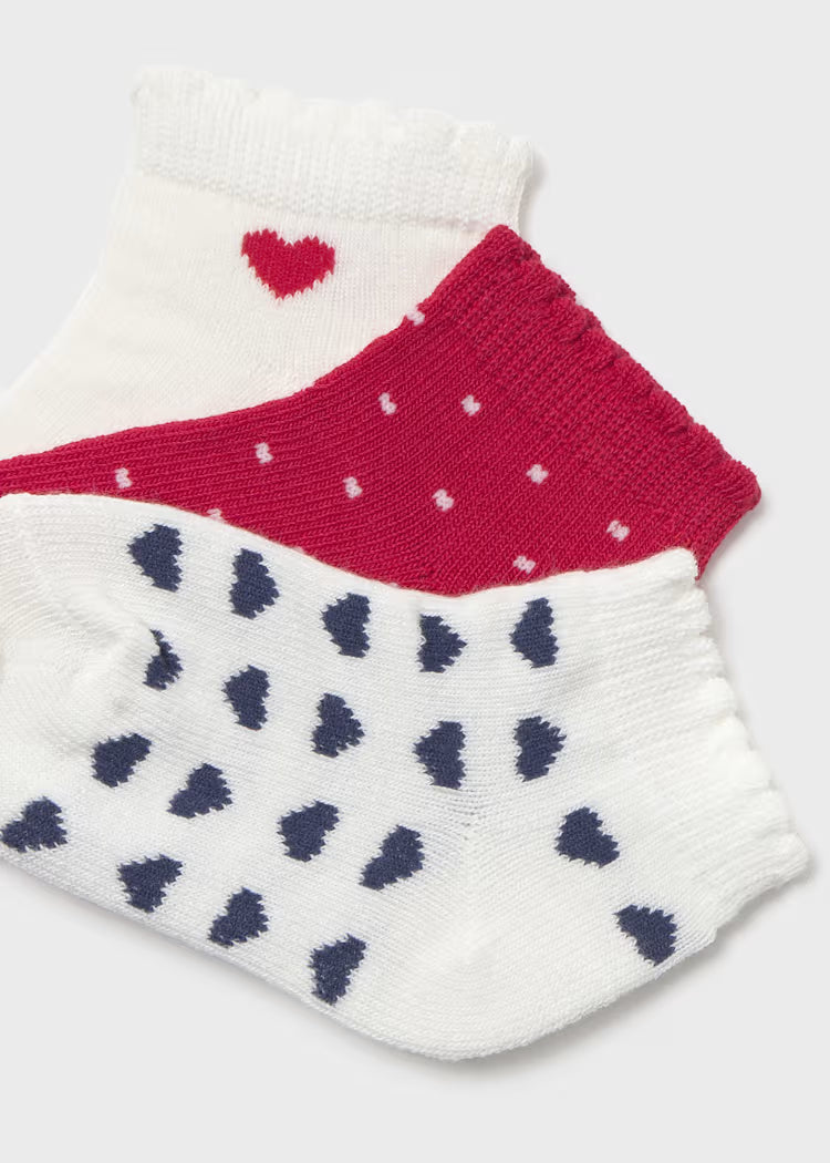 3pairs of patterned socks with hearts on a white background